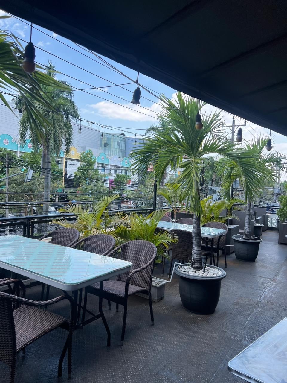 Area rooftop Double Decker dengan kursi rotan dan pemandangan Solo Baru